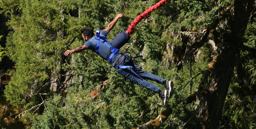 A man tied to a harness and indulging in freefall which is a thrilling activity to try.