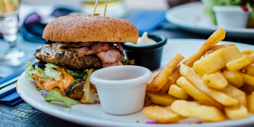 Image of delicious burger with crispy fries served on a plate, perfect for a quick meal.