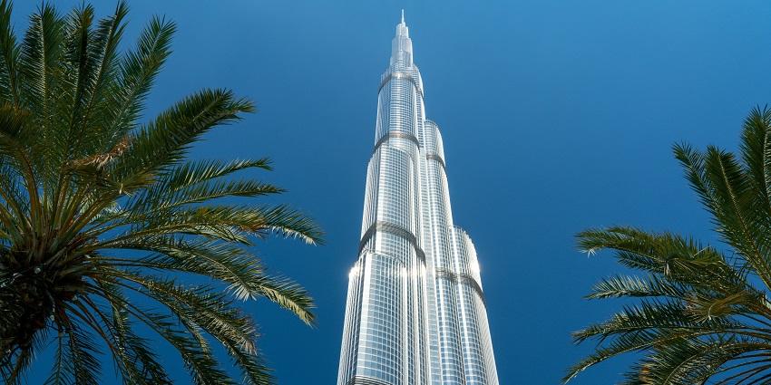 A breathtaking view of the Burj Khalifa in Dubai near palm trees during the daytime.