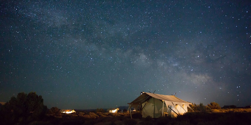 Brown tent under a starry night sky, ideal for camping and stargazing.