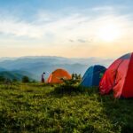 Dome tents pitched on a grassy hilltop - camping in guwahati.