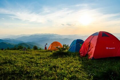 Dome tents pitched on a grassy hilltop - camping in guwahati.