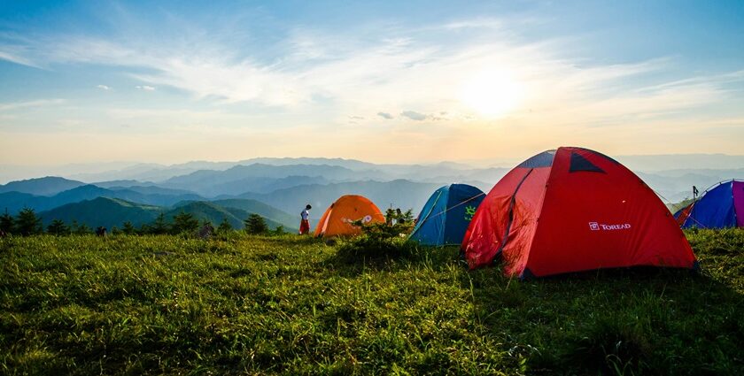 Dome tents pitched on a grassy hilltop - camping in guwahati.