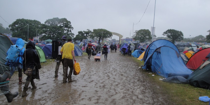 Campsite during bad weather, with muddy ground and tent - weather conditions affect camping.
