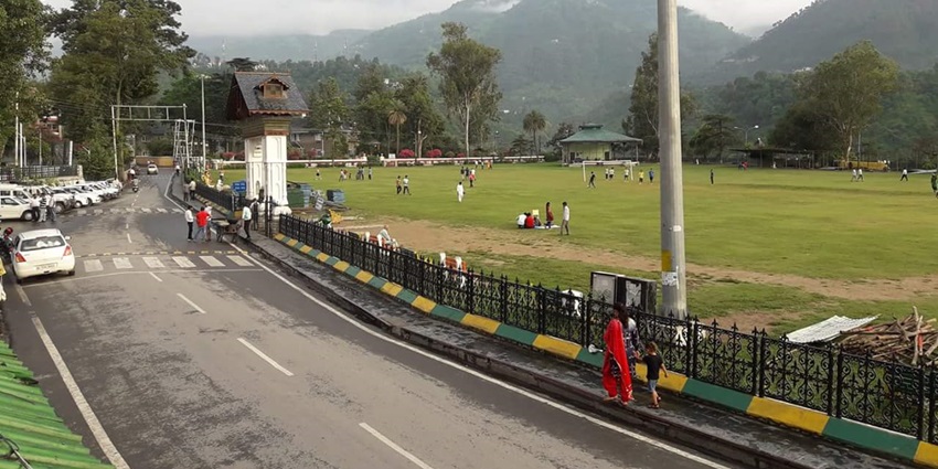 A hill city road with mountains in the background