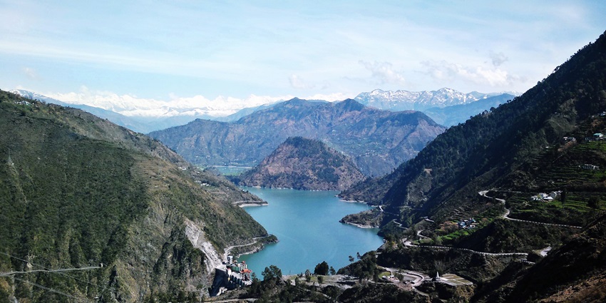 Scenic view of the Chamera lake nestled amidst the forested mountains