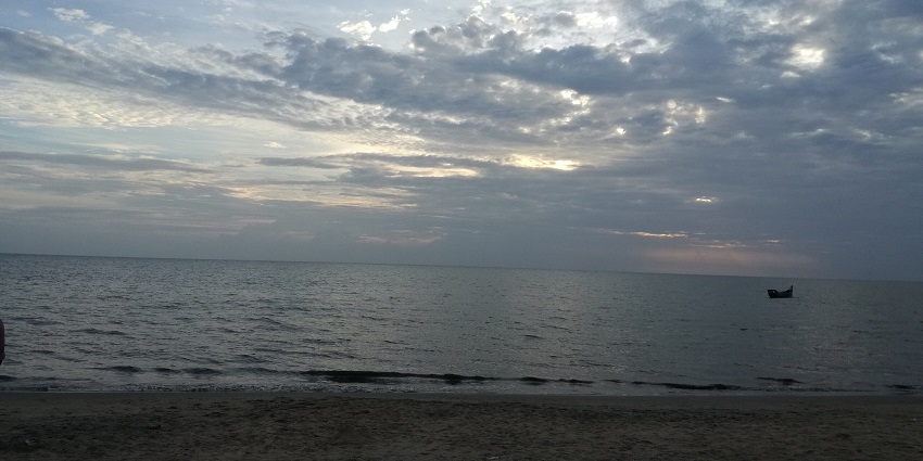 Chavakkad Beach in Kerala with fishing boats, sandy shores, and a calm sea view.