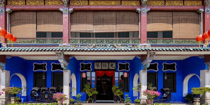 Front view of Cheong Fatt Tze Blue Mansion with bright blue walls and arches