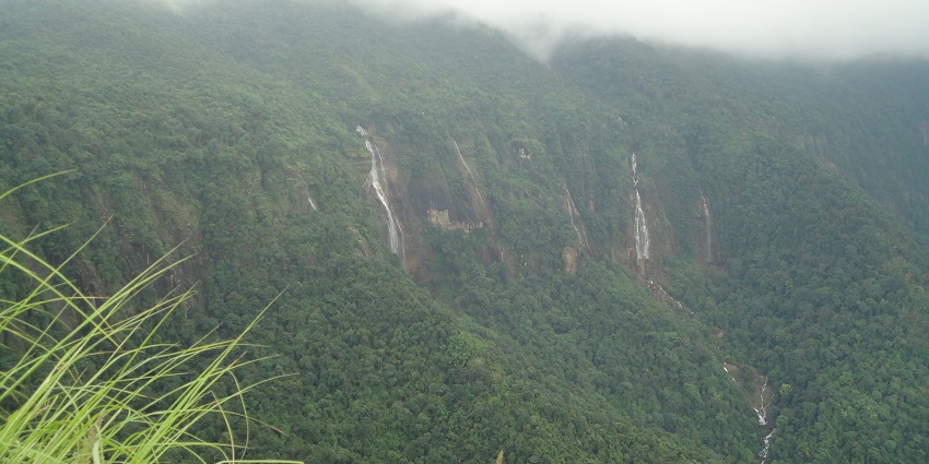 A picture taken from a distance of the famous seven sister waterfall in Meghalaya surrounded by greenery and hills
