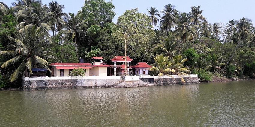 A serene view of Chettuva Backwaters in Thrissur, Kerala, featuring tranquil waters, and lush greenery