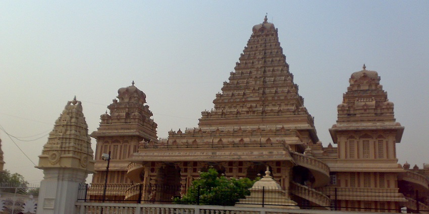 A frontal picture of a traditional Hindu temple, taken from across a busy road