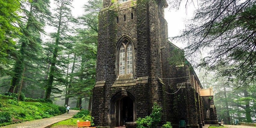 A pleasing view of the St john church amidst lush wilderness with cobblestone trails around