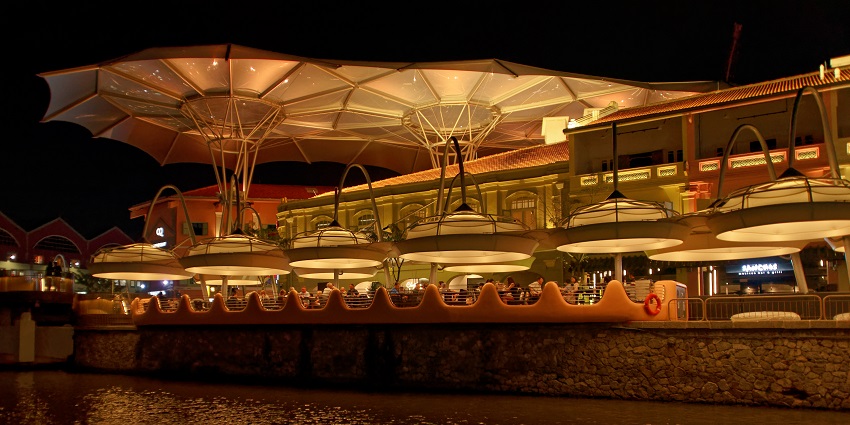 Clarke Quay at night, illuminated with vibrant lights and bustling with lively nightlife.