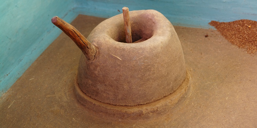 A traditional clay grindstone used in rural Umaria, placed on dry earth in open air.