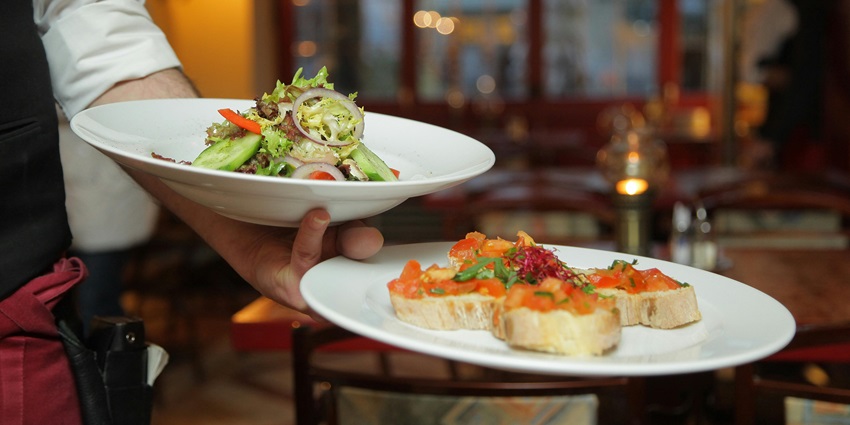 Mouthwatering food along with salad and sweets in the ceramic plate served in Restaurant
