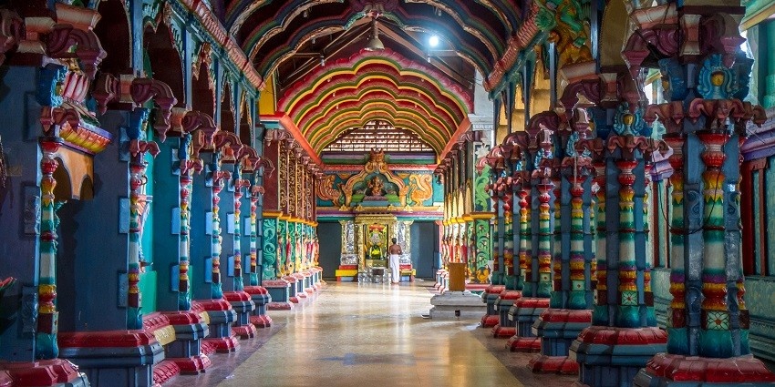 Intricate stone corridors of Naguleswaram temple showcasing detailed carvings.