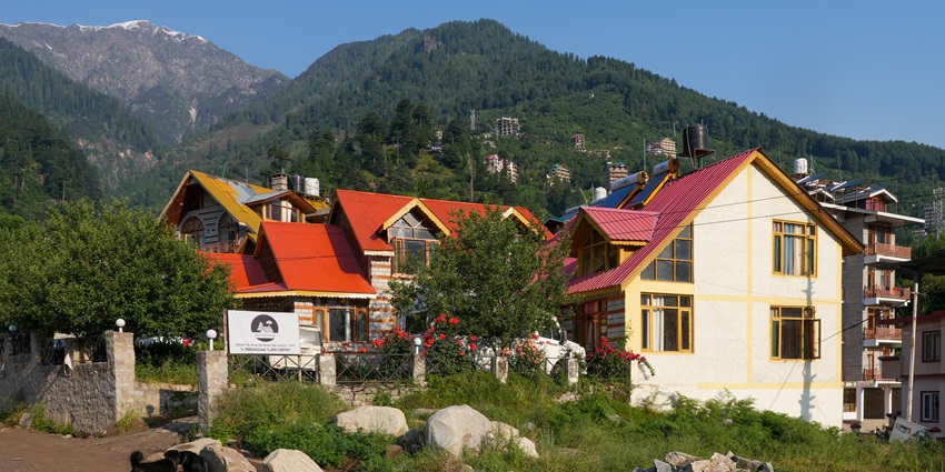 Panoramic snapshot of a cottage with Himalaya in background near Dibang Wildlife Sanctuary