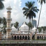 An image of the mosque from outside with incredible architecture and palm trees around it.