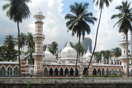 An image of the mosque from outside with incredible architecture and palm trees around it.