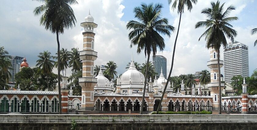 An image of the mosque from outside with incredible architecture and palm trees around it.