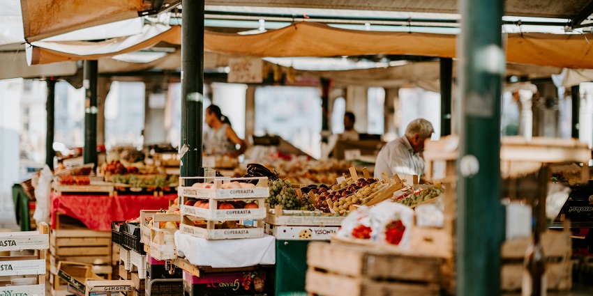 View of a place to get fruits & other daily needs items with an old man in the background.