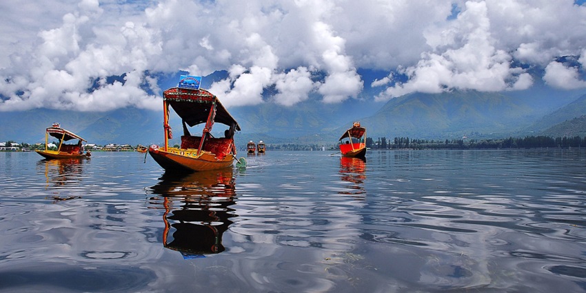 ky hues dancing on the water with shikaras sailing in the lake, offers a picturesque view