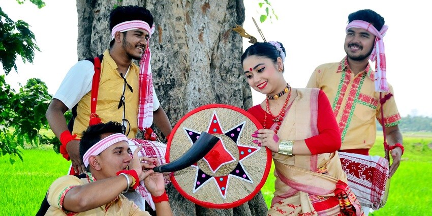 Dancers performing Bihu, the traditional harvest festival of Assam, in vibrant attire.