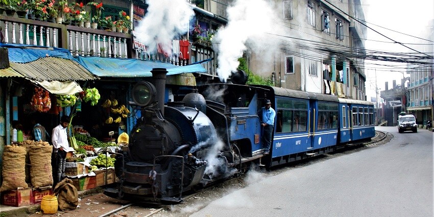 Darjeeling Himalayan Railway train passing a fruit and vegetable shop in Darjeeling en route to the main train station.