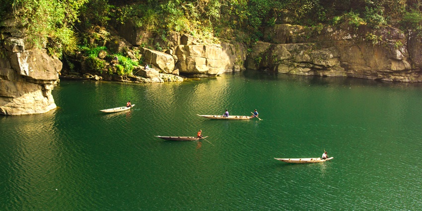 A picture of numerous fishermen on small boats engaged in fishing in a river in Meghalaya