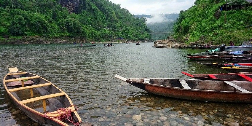 A picture of a river with small boats sailing in it during day time