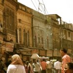 An image showing people on the street during daytime amidst the scorching heat.