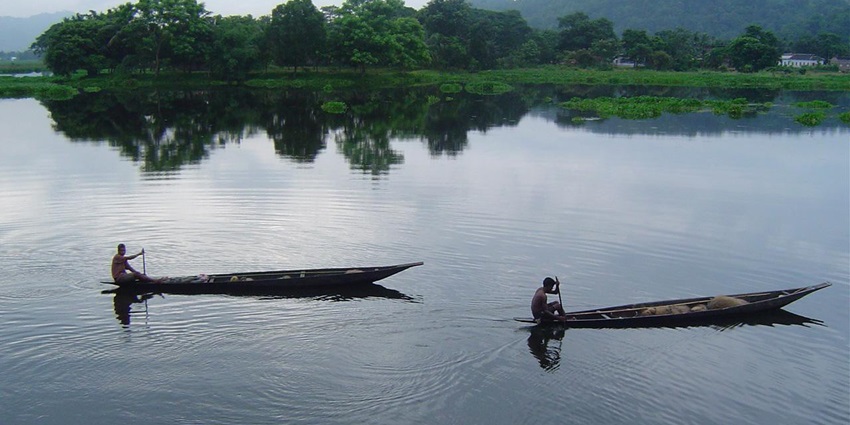 Scenic view of Deepor Beel with calm waters, surrounding greenery, and distant hills.