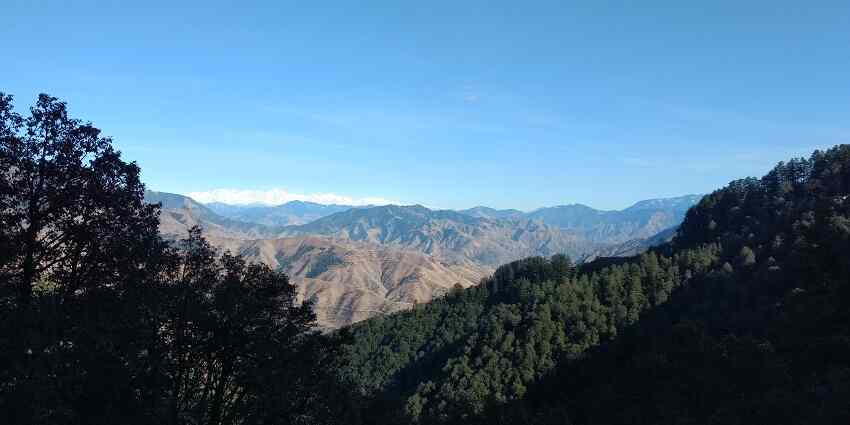 Panoramic view of the forested hills of Dehradun with snow capped mountains far beyond