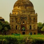 A breathtaking view of a historical monument in Delhi surrounded by lush greenery.