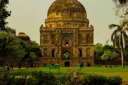 A breathtaking view of a historical monument in Delhi surrounded by lush greenery.