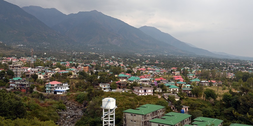 A picture of a mountain range taken from a distance with numerous houses in between