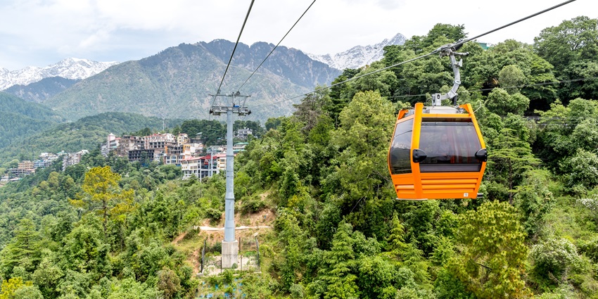Scenic view of Dharamshala with mountains and vibrant greenery under a clear sky.