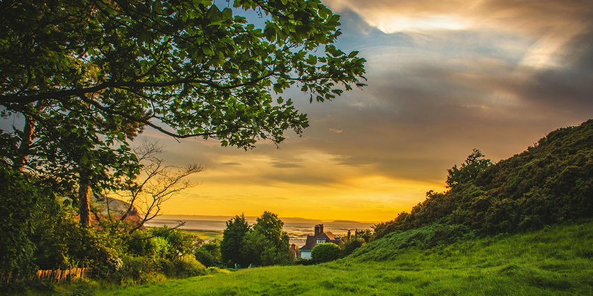 Snapshot of a beautiful hill sunset viewpoint covered in the green field of grass
