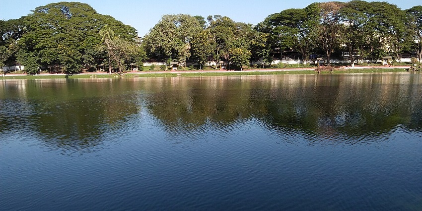 Dighalipukhuri, featuring a serene lake, surrounding greenery, and peaceful ambiance