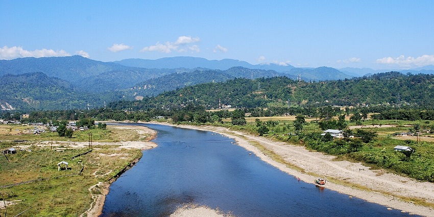 Dikrong River flowing through a scenic landscape with lush greenery and tranquil waters.