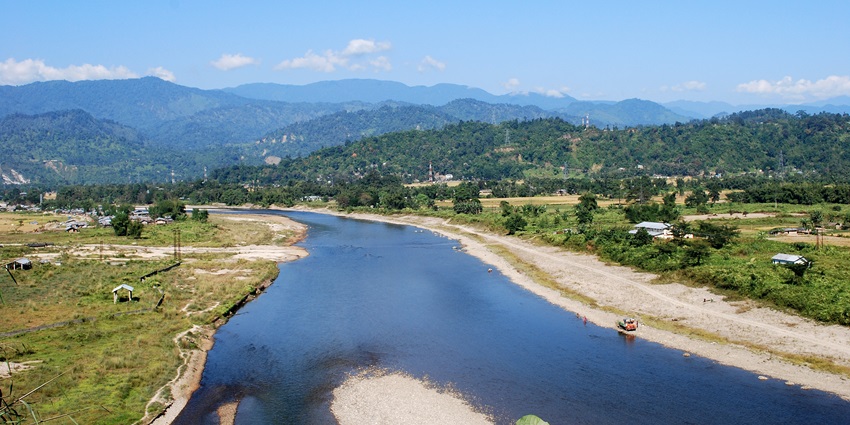 A picture of a beautiful river flowing through Itanagar with blue waters, surrounded by greenery