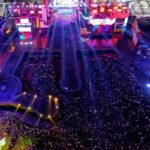 An aerial picture of a music festival happening during night time with a big crowd