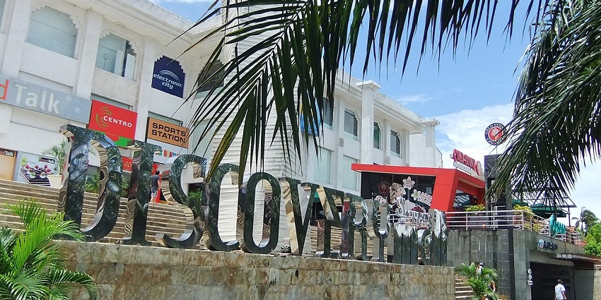 A picture of a shopping mall in Bali taken from behind a tree during daytime