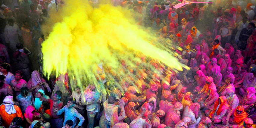 A picture of a group of people playing Holi with various colours and water