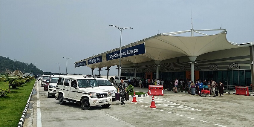 Donyi Polo Airport with its modern terminal, set against a backdrop of rolling hills.