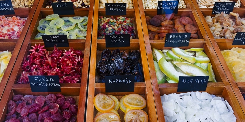 An image of dry fruits and nuts like strawberries, kiwi & orange slices in display cases