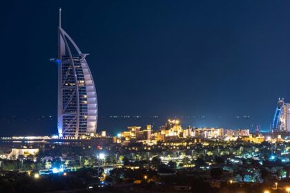 A picture of Dubai's beautiful skyline during nighttime with lights blinking from buildings