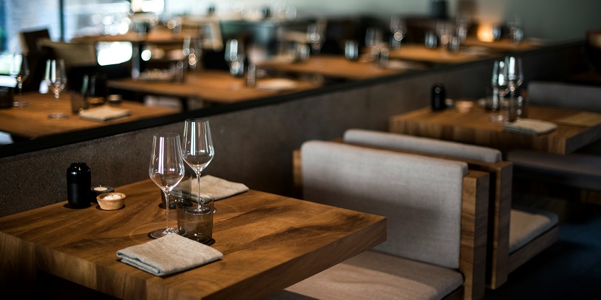 Clear drinking glass placed on a brown wooden table, highlighting the textured surface.