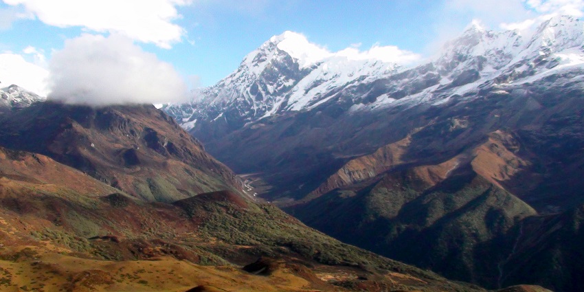 Mesmerising view of the verdant hills of Dzongi trek overlooking the snow covered Himalayas