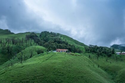 A picture with lush greenery and clouds surrounding it, making it a scenic view to witness.